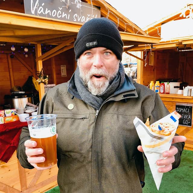 J.D. enjoying Christmas market food on a cold day in Prague